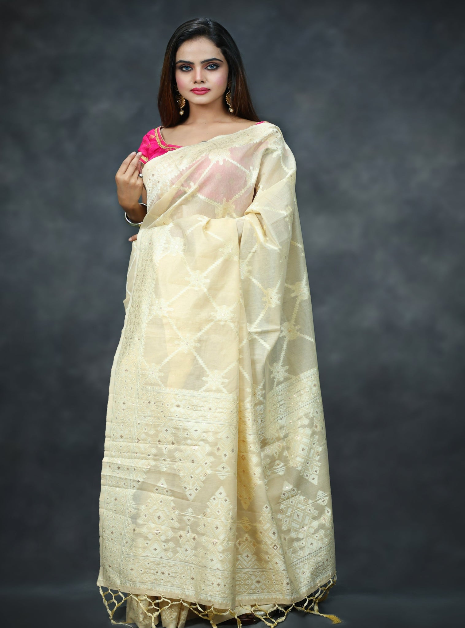 Raj Nandini In Cream Banarsi Silk Saree With Meena Border And Booti Work. Available in 3 colours.